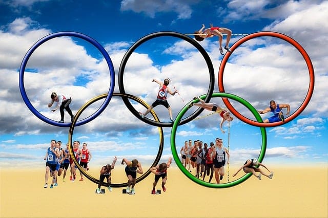 Anneaux olympiques avec des personnes sur une plage