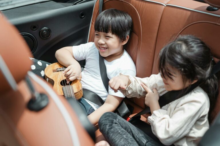 Deux enfants s'amusent à l'arrière d'une voiture.